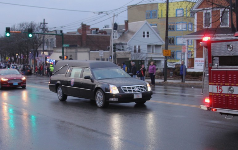 The hearse carrying fallen Boston Fire Lt. Edward Walsh rolls through Watertown on Friday evening.
