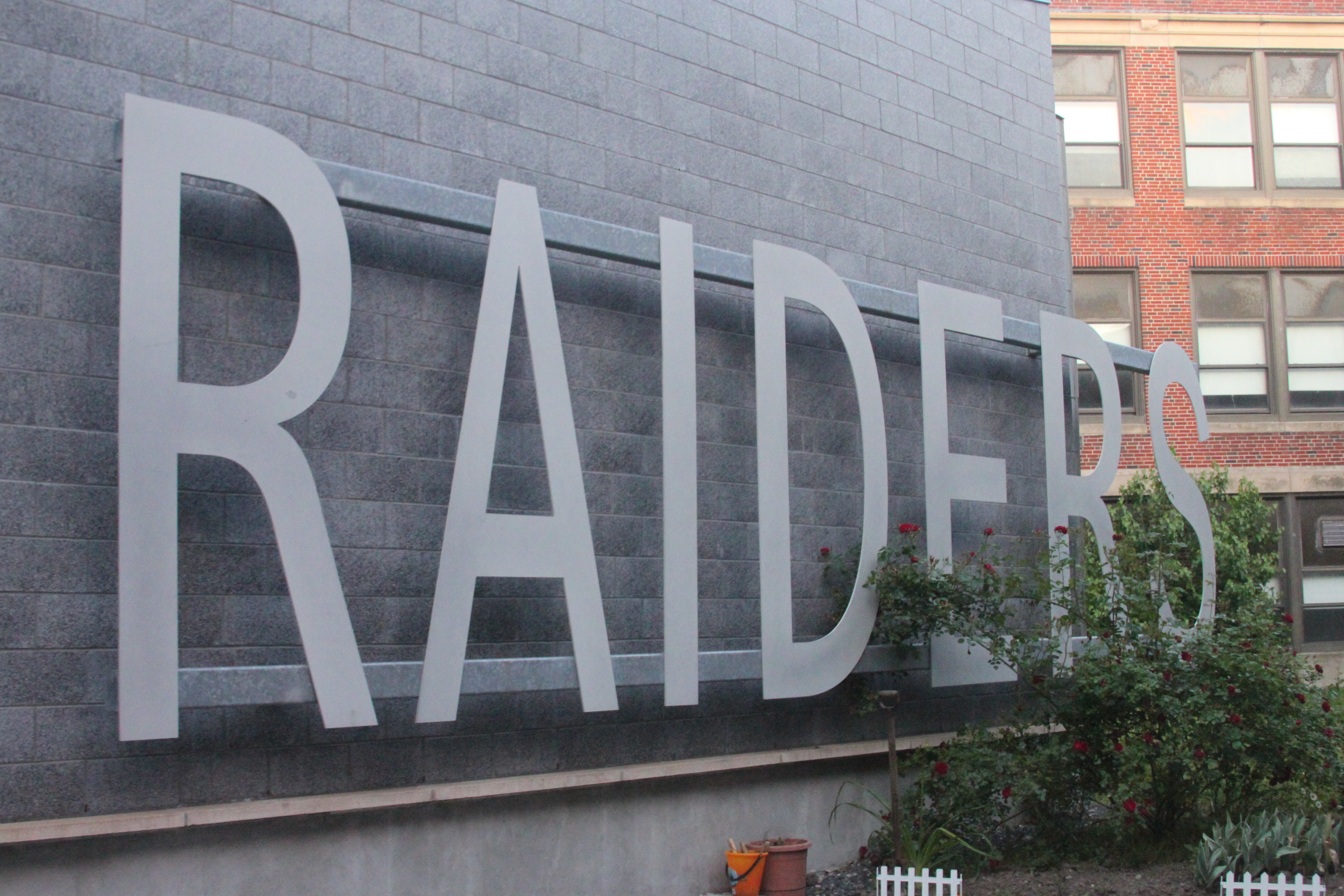 A sign inside an atrium at Watertown High School displaying the current mascot - the Raiders.