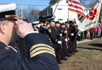 Color guards from the Watertown Police and Fire departments salute the raising of the new Watertown Strong flag.