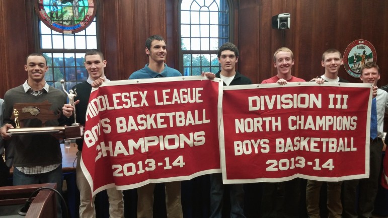 The WHS boy's basketball team displays two banners - the Middlesex League title and the North Section Title. 
