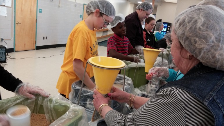 Watertown Middle School students and Watertown Rotary Club members pack meals that will be sent to schools in Panama.