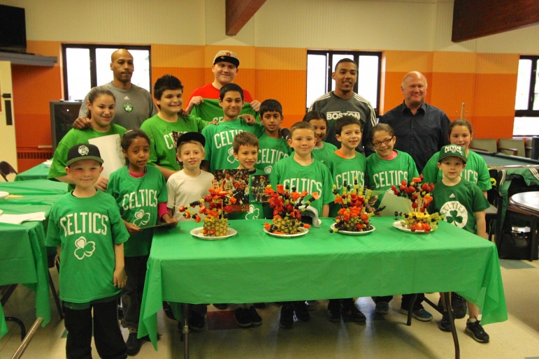The Celtics pose with children at the Watertown Boy's & Girl's Club. Back left, former Celtic Dana Barros, second from right in the back is Celtic guard Phil Pressey and back right is Arthur Margolis, president of America's Compounding Center in Newton.