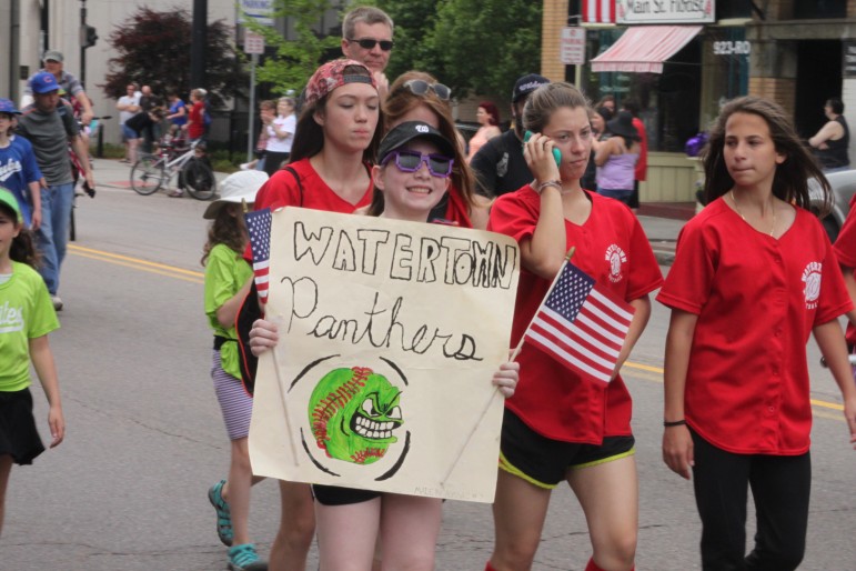 Members of a Watertown Youth Softball team marches in the Memorial Day Parade.