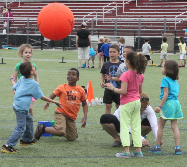 Youngsters from the Lowell School try to keep a large ball aloft during Field Day at Victory Field.