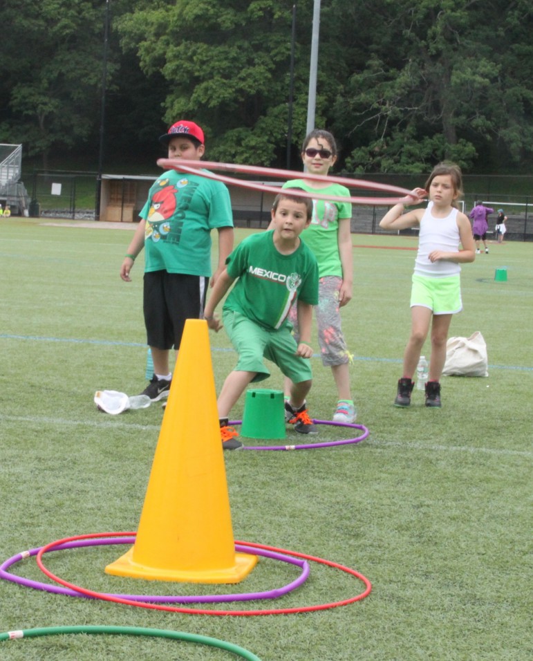 A Lowell student tries to toss a hula hoop over a cone. 