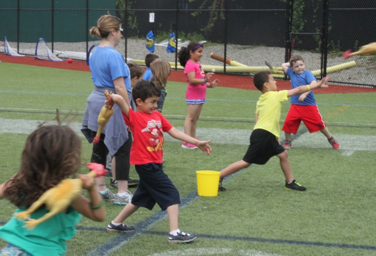 Kids test their arms by hurling rubber chickens during Lowell's Field Day.