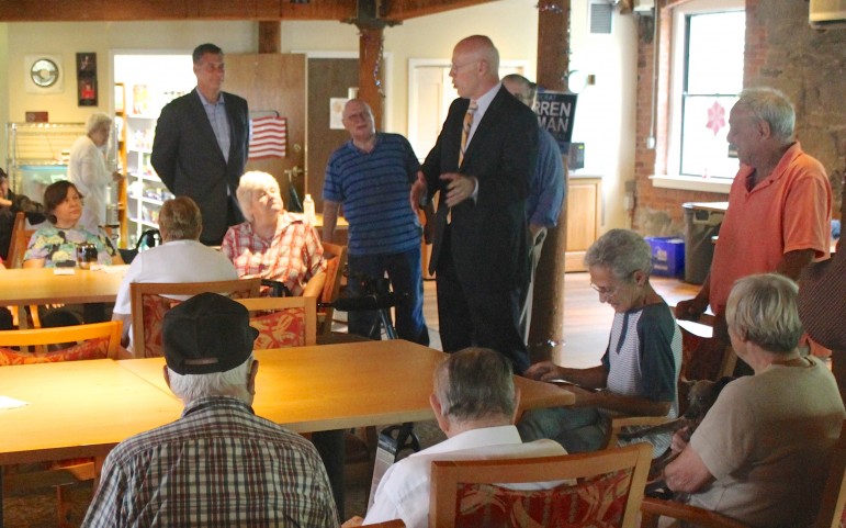 Attorney General candidate Warren Tolman and Middlesex Sheriff Peter Koutoujian speak at a senior living facility in Waltham.