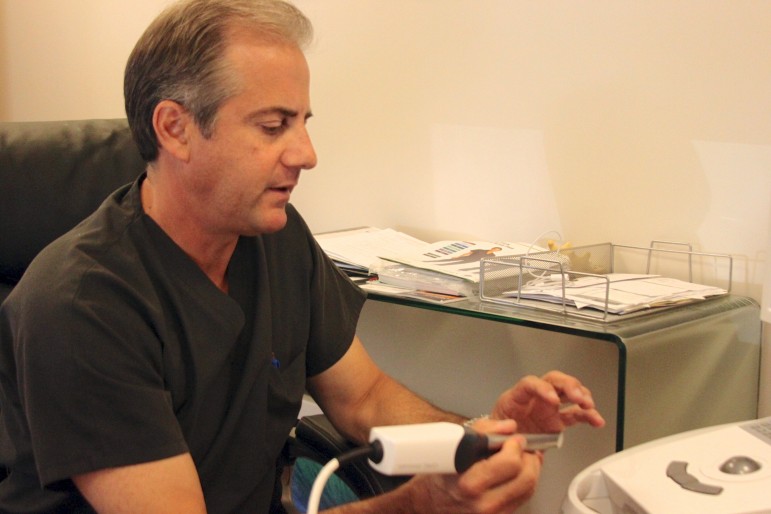 Dentist Dan D'Amico demonstrates some of the technology he uses at his practice.