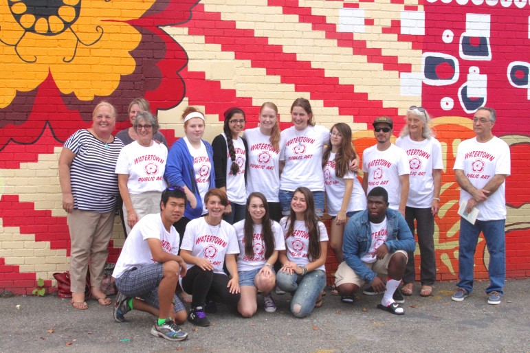 Students who painted the "Tapestry of Cultures" mural in Watertown Square pose with members of the Watertown Cultural Council.