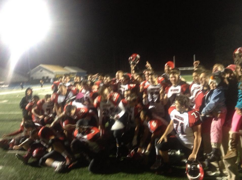 The Watertown football team celebrates winning the Middlesex League after beating Winchester Friday night.
