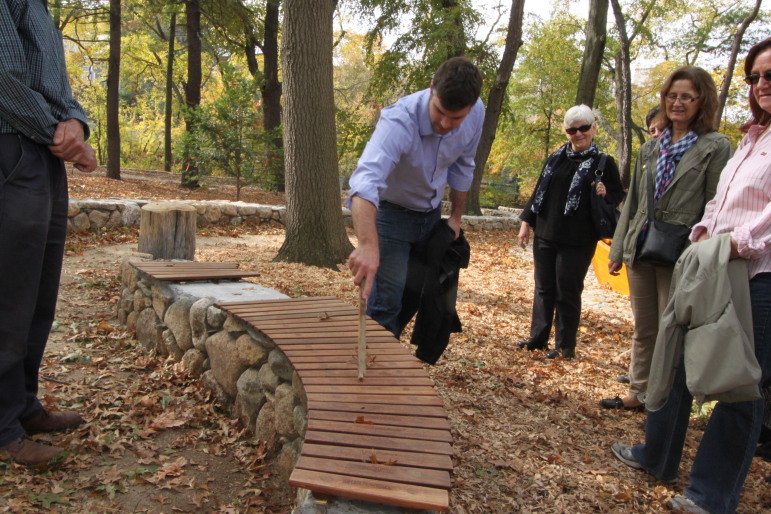 Travis Mazerall of Sasaki Associates demonstrates the musical bench near Charles River.