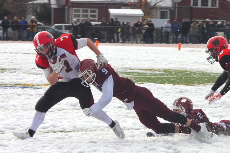 Watertown senior running back tries to escape a Belmont tackler in the Thanksgiving Game, won 34-13 by the Raiders.