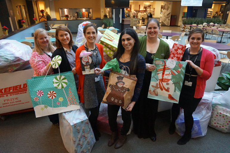 Tufts Health Plan employees Jean Geraghty, Sarah Rush, Kayla Romanelli, AnnMarie Picone, Kristyn McCandless, Caite O'Brien stand with with the gifts donated by employees of the company.