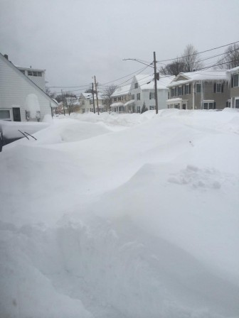 A car is hiding in this snow bank on Fayette Street. 