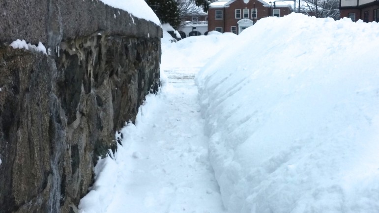 A pile of snow blocks the end of a shoveled sidewalk in Watertown.