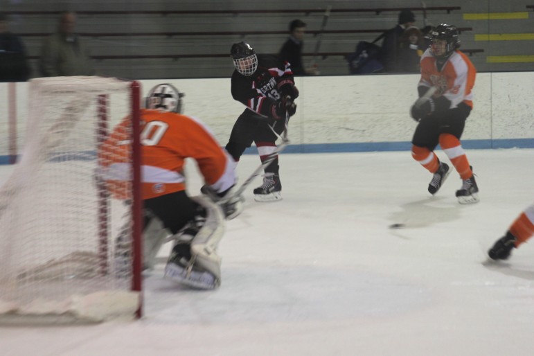Junior Tyler Poulin centers the puck during Watertown's Div. 3 North Section semifinal victory at the Chelmsford Forum.