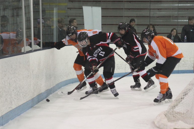 Junior forward Tyler Poulin scraps for the puck against Wayland. He and the Raiders take on Bedford in the Div. 3 North Section Final on Friday.