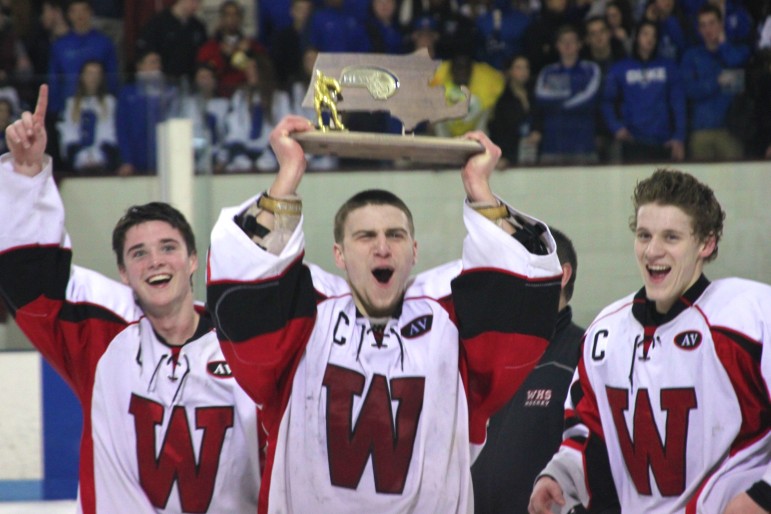 Senior goalie Anthony Busconi holds the Div. 3 North Section trophy up for the crowd after beating Bedford.