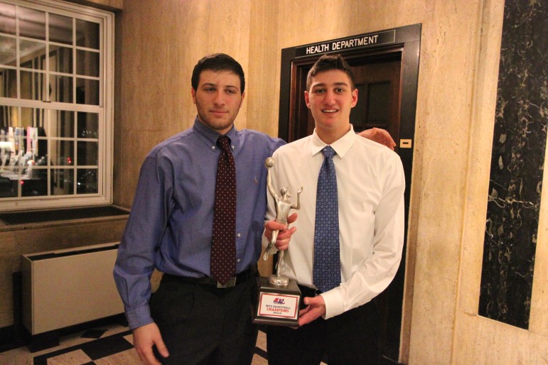 Watertown High School boys basketball captains Andrew Massarotti and Mike Hagopian show off the Middlesex League title trophy.