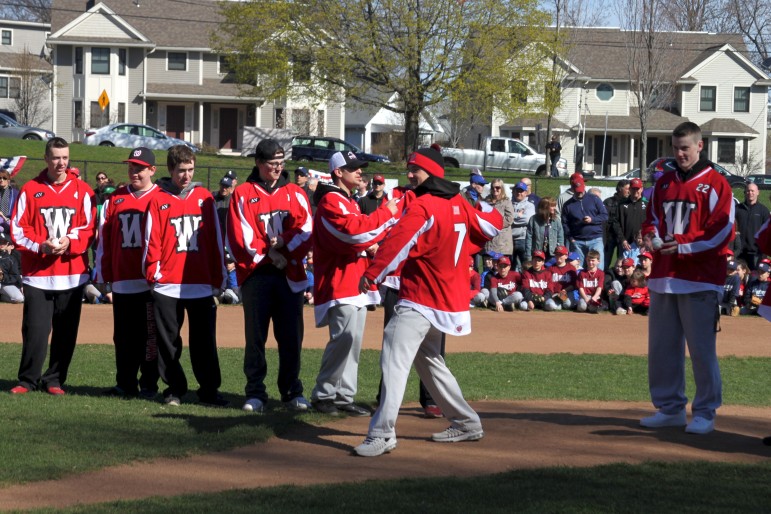 Members of the Watertown High School state championship boys' hockey team threw out the first pitch on Little League opening day.