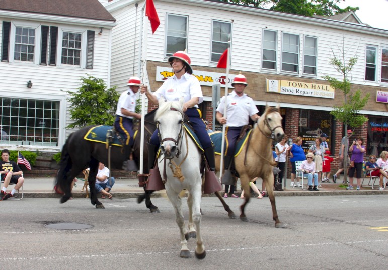 A group of lancers ride their horses down Main Street during the Memorial Day Parade.