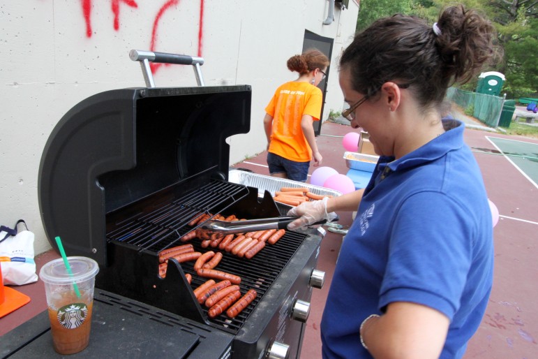 Renee Gaudette, executive director of the Watertown Boys and Girls Club cooks hot dogs for the members of the club.