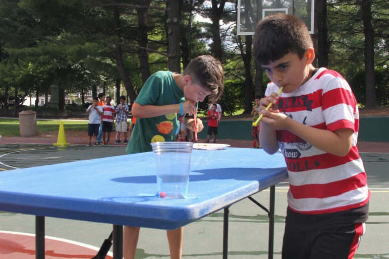Watertown Boys and Girls Club members picked up and moved Skittles into cups using only a straw during an end of the year Field Day.