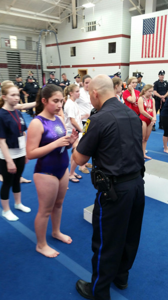 A Watertown Police officer honors one of the Special Olympics competitors.