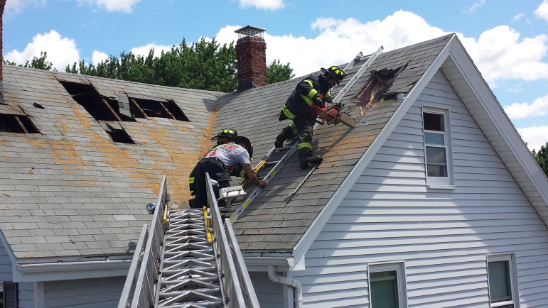 Watertown Firefighters would normally only cut into a roof during an actual fire. Here, Lt Dan LaVache, left, firefighter Kevin MacDonald and firefighter Diego Ribeiro, right, take their turn training on the home on Harrington Avenue.
