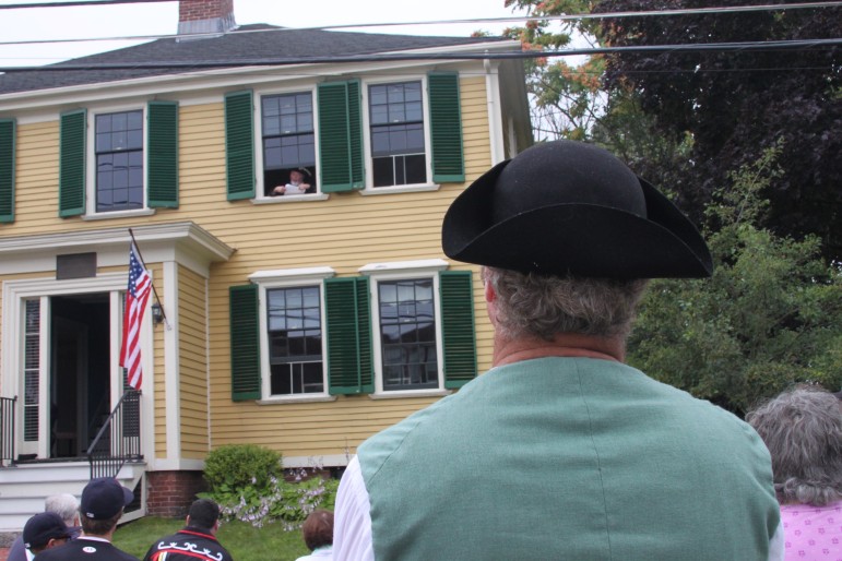 A colonial re-enactor listens to a reading of the Declaration of Independence from the Edmund Fowle House on Marshall Street during the Historical Society of Watertown's celebration.