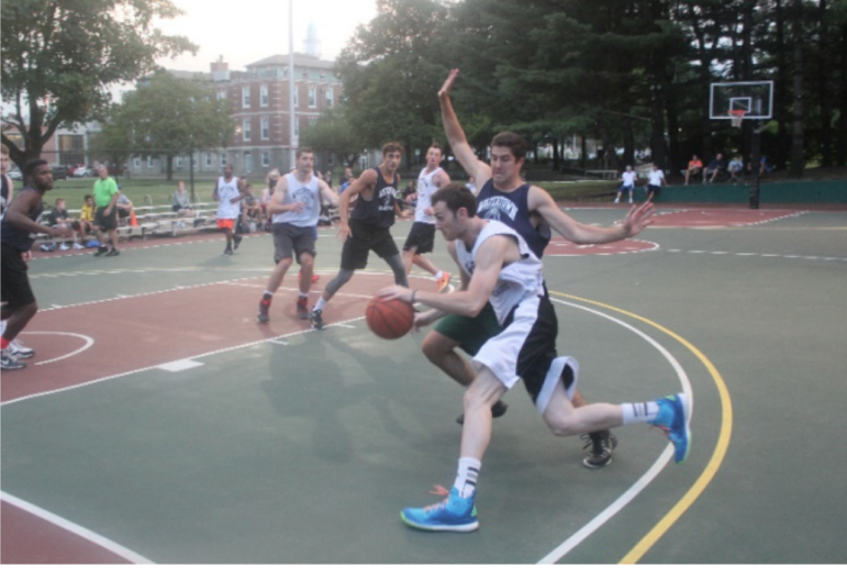 Players clash on the Saltonstall Park basketball court during the Watertown Summer Basketball League playoffs.