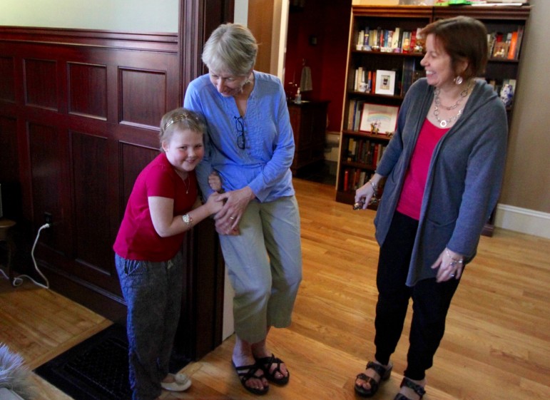 Kate Morris was diagnosed with cancer in January 2014 and hopes to finish treatment in early 2016. Here the 7-year old hugs her aunt Martha Krache's arm as her mother, Evelyn Krache Morris, looks on.