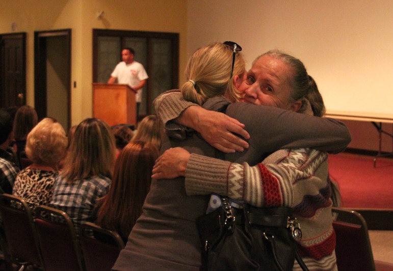 Carol Morris, right, receives a hug after talking about losing four children to drugs during the Watertown Overcoming Addiction Candlelight Memorial Vigil.