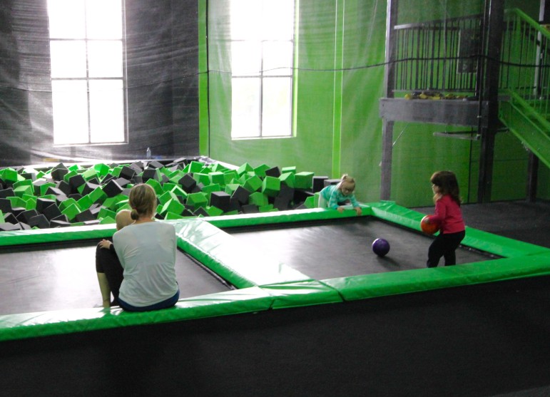 A parent plays with her young children on trampolines at Launch Watertown during Toddler Time.