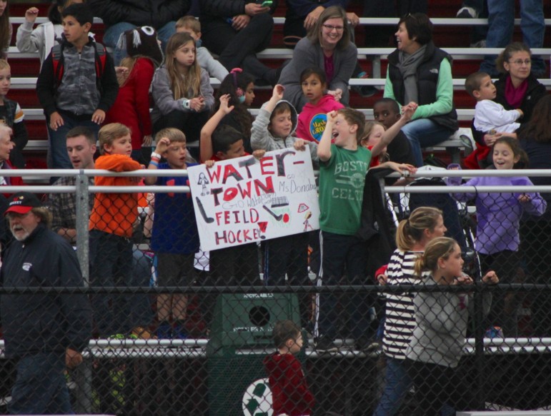 A group of children hold a sign cheering on the Watertown field hockey team in their 154th straight unbeaten game. 