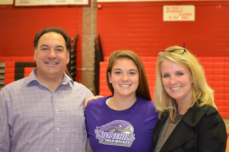 Field hockey player Michaela Antonellis, center, poses with her parents, Mike and Elaine, after officially signing to play at Stonehill College.