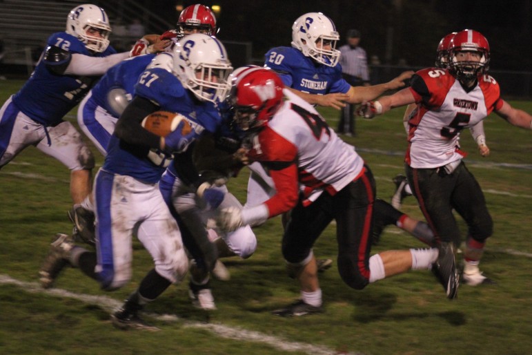 Watertown's Tyler Poulin rushes in to tackle Stoneham running back Evan Taylor. 