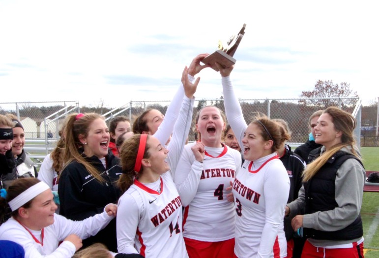 Watertown field hockey captains Michaela Antonellis, right, and Ally McCall, center lift the North Section championship trophy with junior Kourtney Kennedy lending a hand.