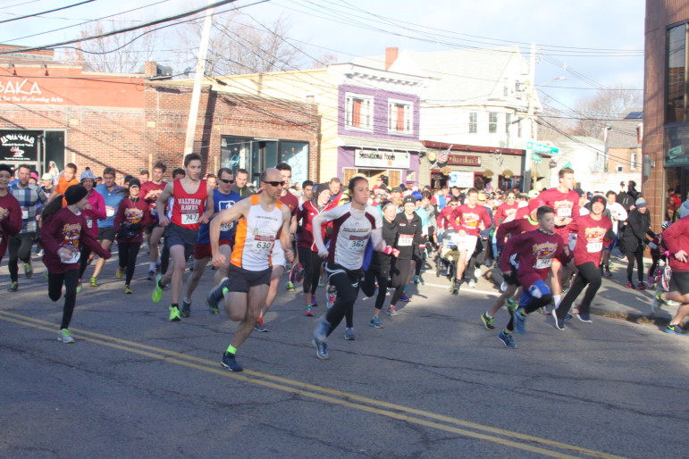 Runners take off at the beginning of the Turkey Trot. The top male and female runners can be seen: Roger Lacroix, in the red "Waltham Hawks" jersey, and Michelle Taverner in white in the center of the photo.