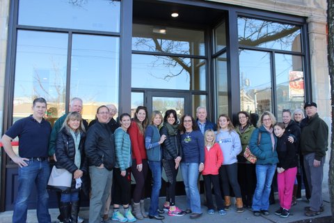 Teachers, family and friends - including owner Liz Padula (center, wearing glasses) celebrate the opening of Artemus Yoga in Coolidge Square.