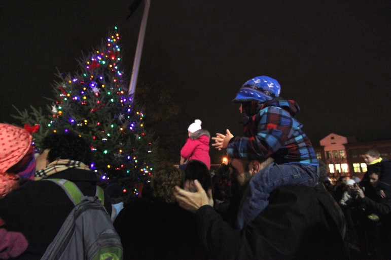 A father and son applaud the lighting of the tree in Watertown Square on Friday night.