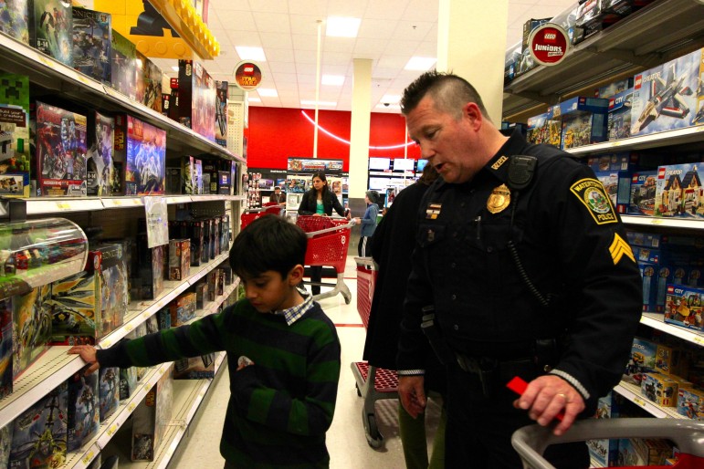 Watertown Sgt. John MacLellan looks for toys with a young boy during the Shop With a Cop event at Target.