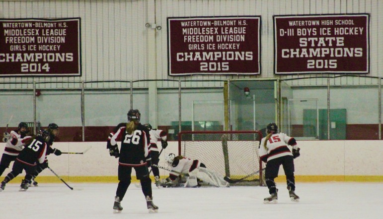  Goalie Jonna Kennedy reaches for the puck in front of the banner the Watertown girls hockey team got for winning the Middlesex League in 2015.