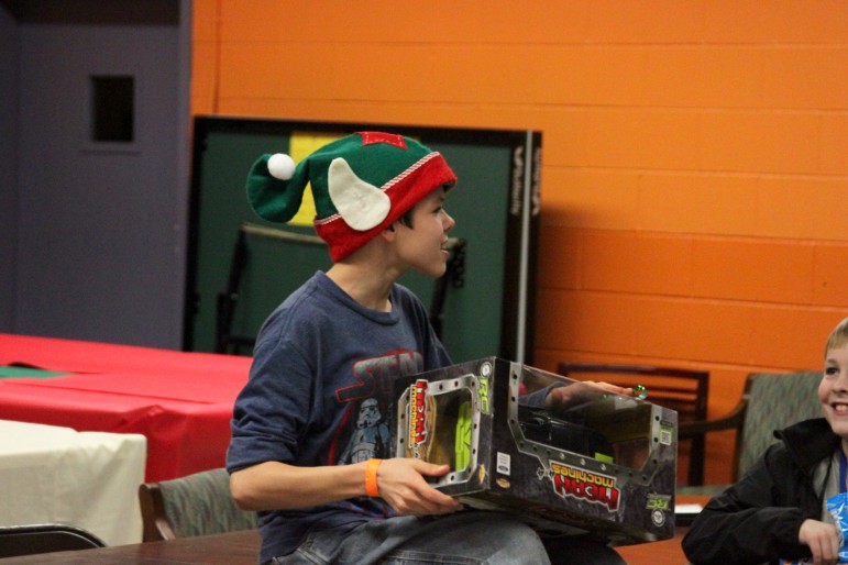 A member of the Watertown Boys and Girls Club with the present he received at the Holiday Celebration.