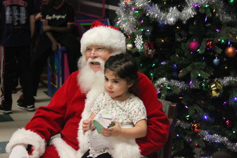 Santa Claus poses with a young girl at the Watertown Boys and Girls Club.