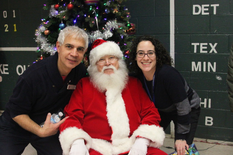 Boys and Girls Club Board President Paul DerBoughian and Club Executive Director Renee Gaudette pose with Santa at the Club's Holiday Celebration.