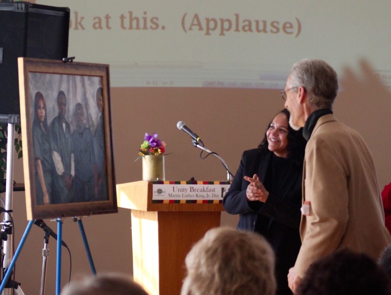 Andrea James, the keynote speaker at the Unity Breakfast, admires a portrait along with the artist who created it, Watertown's Michael Altarmari.