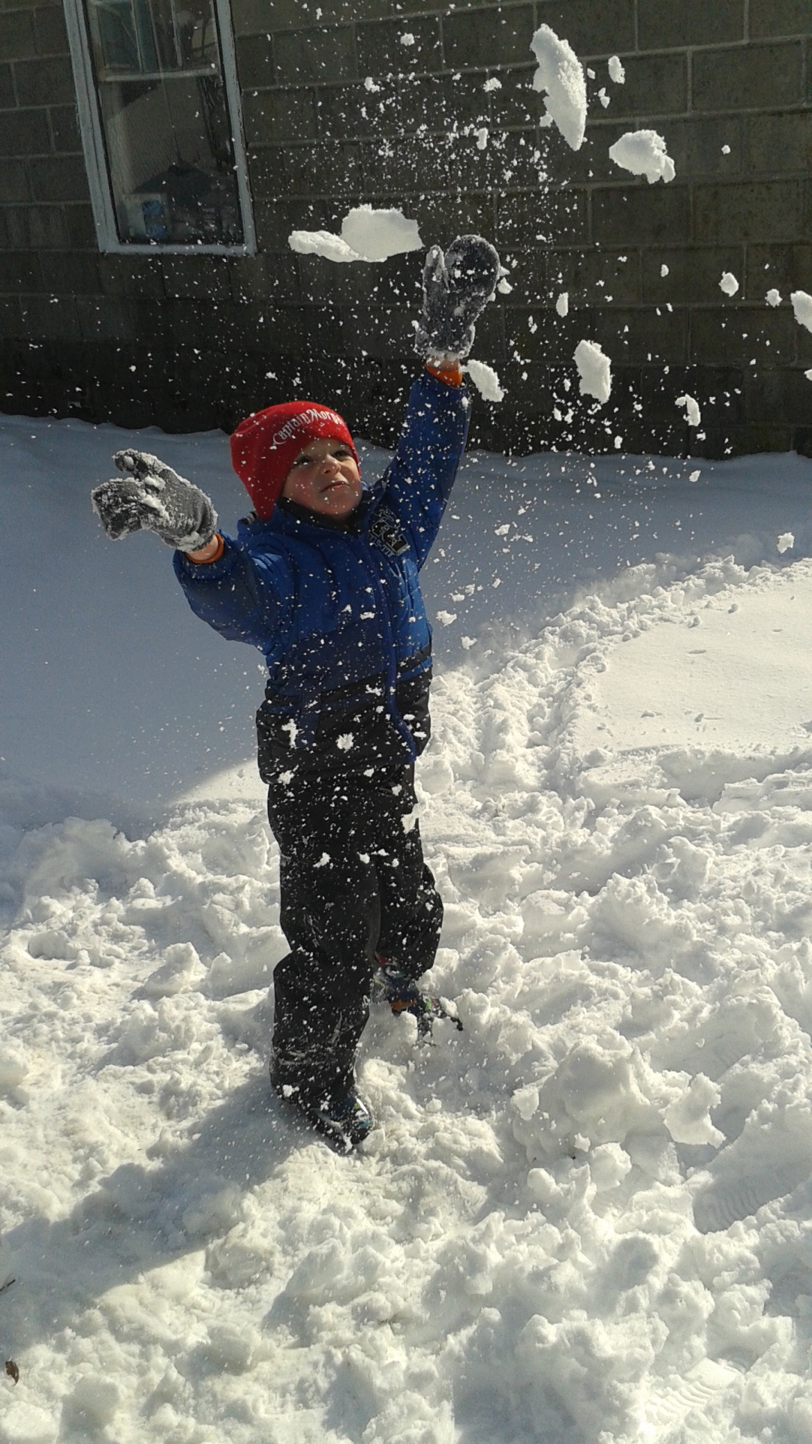 4-1/2 year old Jack plays in the snow making "snow confetti" during Monday's storm. 
