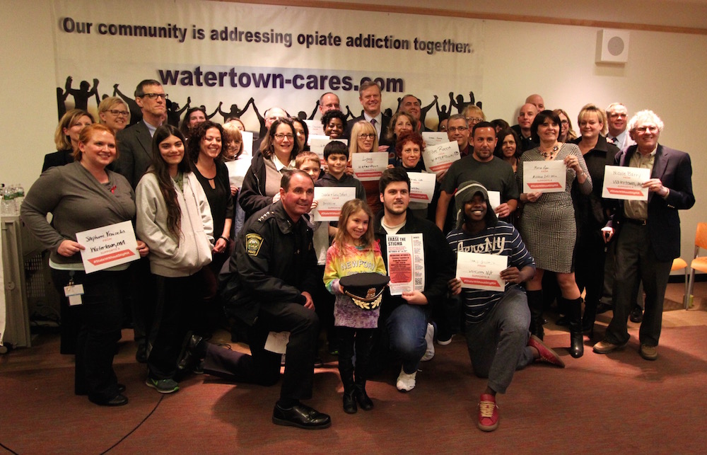 A group of people who took the pledge to support the state's #StateWithoutStigMA effort pose with Gov. Charlie Baker at the Watertown Library.