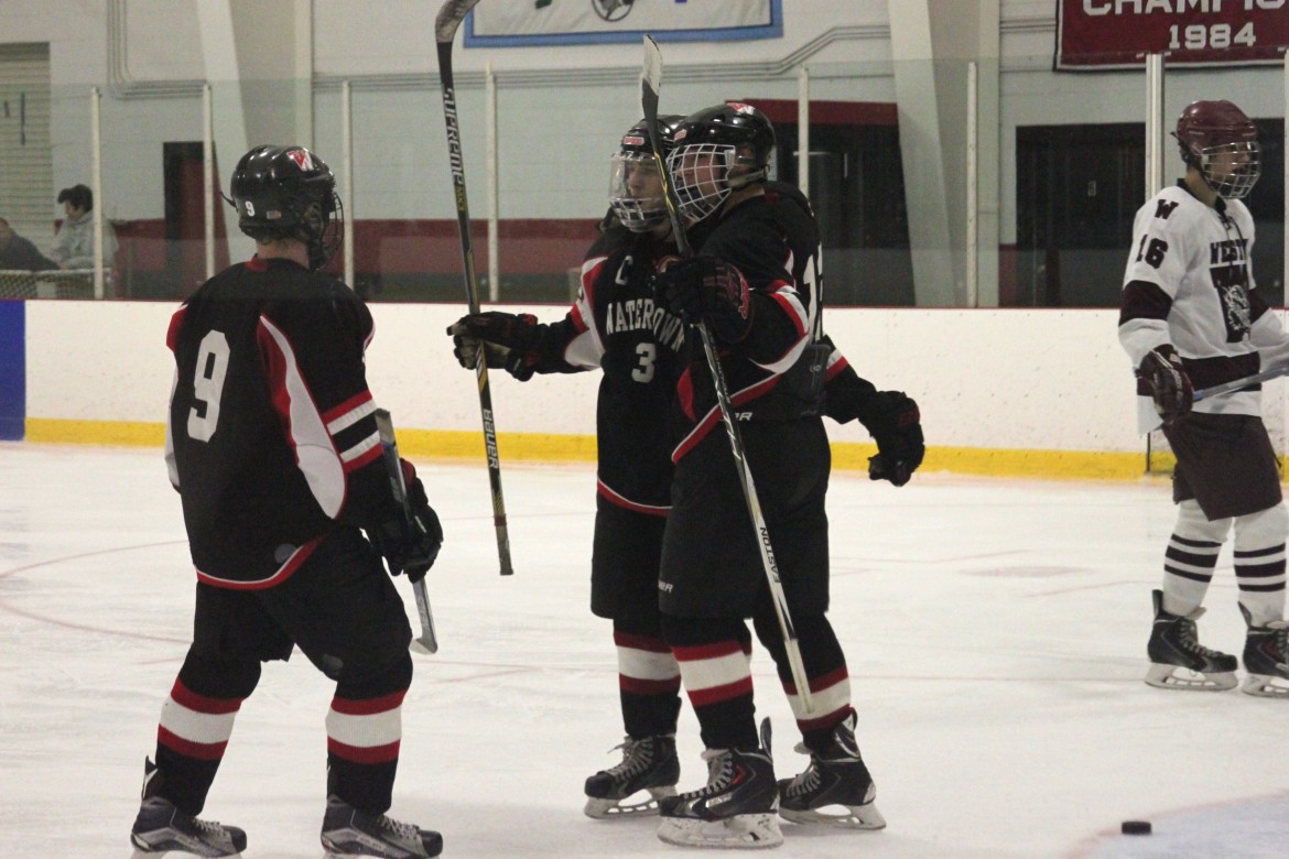 Senior Tyler Gardiner, left, celebrates with seniors Mike Giordano (center) and Tyler Poulin after Giordano scored in the third period against Weston.